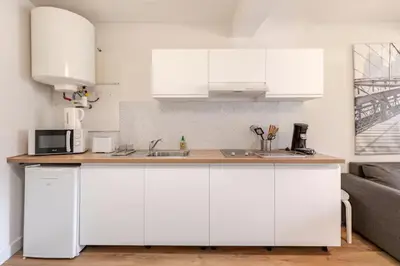 a kitchen with white cabinets and a counter top at Appartement 