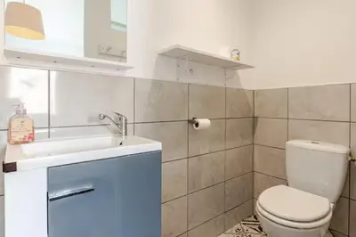 a bathroom with a white toilet and a sink at Appartement 
