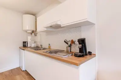 a kitchen with white cabinets and a counter top at Appartement 