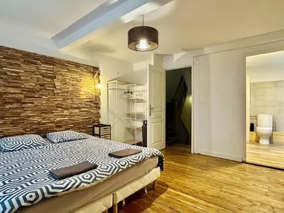 a bedroom with a bed and a brick wall at Maison Jebari - Carcassonne centre in Carcassonne