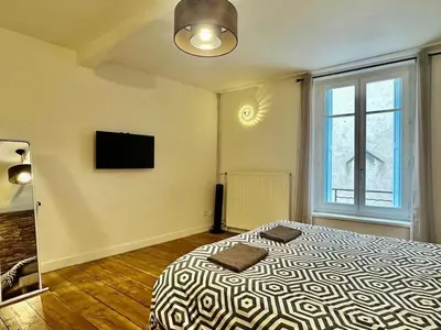 a bedroom with a bed and a flat screen tv at Maison Jebari - Carcassonne centre in Carcassonne