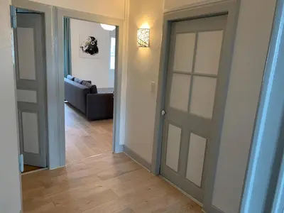 a hallway with two doors and a living room at Elégant Appartement T3 hypercentre de Mazamet in Mazamet