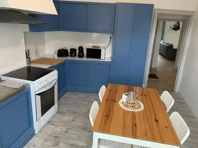 a kitchen with blue cabinets and a wooden table at Elégant Appartement T3 hypercentre de Mazamet in Mazamet