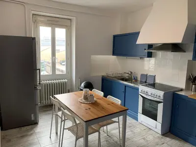 a kitchen with blue cabinets and a wooden table at Elégant Appartement T3 hypercentre de Mazamet in Mazamet