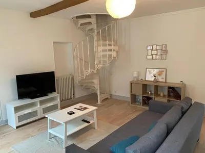 a living room with a couch and a spiral staircase at Elégant Appartement T3 hypercentre de Mazamet in Mazamet