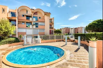 a swimming pool in front of a building at APPARTEMENT SUR LE PORT DE Gruissan in Gruissan