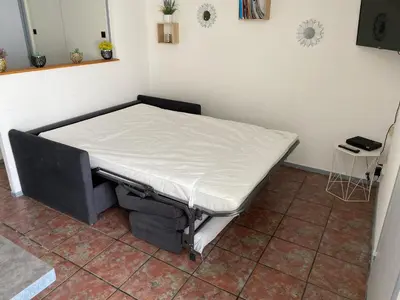 a bedroom with a bunk bed with white sheets at APPARTEMENT SUR LE PORT DE Gruissan in Gruissan