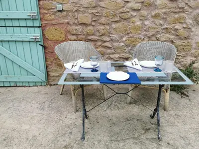 a glass table with two chairs with plates and glasses at Residence La Borde in Plavilla