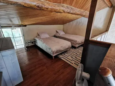 an attic room with two beds and a tv at Residence La Borde in Plavilla