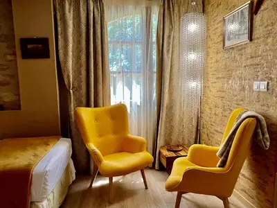 a bedroom with yellow chairs and a bed and a window at Residence La Borde in Plavilla