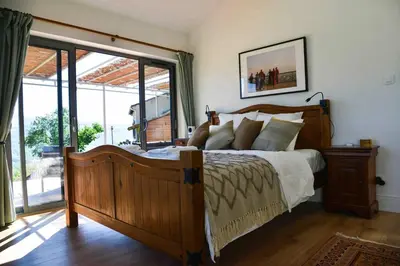 a bedroom with a large bed and a large window at The Restoration Place Pyrenees in Roquefixade