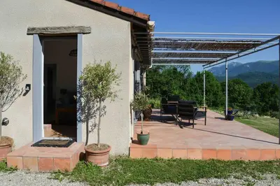 a house with a patio with a table and chairs at The Restoration Place Pyrenees in Roquefixade