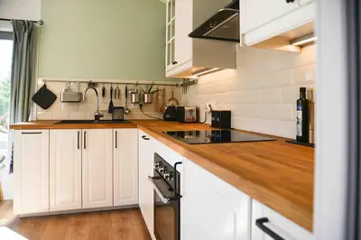 a kitchen with white cabinets and a wooden counter top at The Restoration Place Pyrenees in Roquefixade