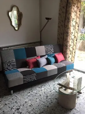 a couch with colorful pillows in a living room at Maison DELMAS, l'Oustal du Recantu in Sainte-Eulalie