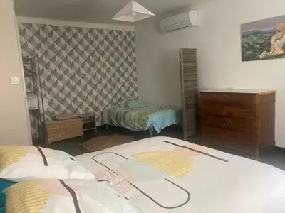 a room with two beds and a dresser in it at Maison DELMAS, l'Oustal du Recantu in Sainte-Eulalie