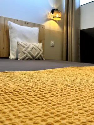 a bedroom with a bed with a yellow comforter at Côté Nuit in Capestang