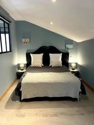 a bedroom with a large bed with blue walls at Côté Nuit in Capestang