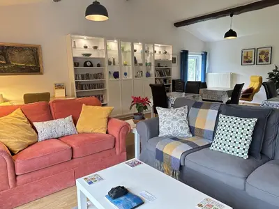 a living room with two couches and a table at Les Deux Chevaux Chambres d’Hôtes in Rouvenac