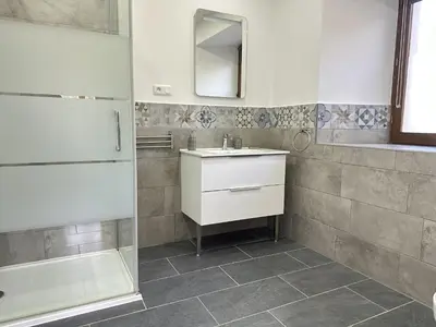 a bathroom with a sink and a mirror and a shower at Les Deux Chevaux Chambres d’Hôtes in Rouvenac