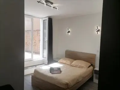 a bedroom with a bed and a window at Cosy Centre Ville Narbonne in Narbonne