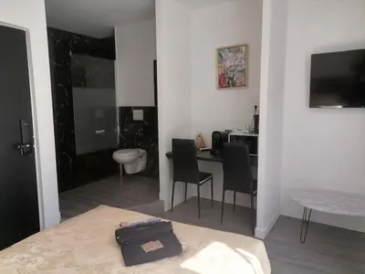 a room with a bed and a desk with chairs at Cosy Centre Ville Narbonne in Narbonne
