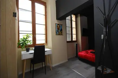 a room with a desk and a bed and window at Baignoire Cosy Centre Narbonne in Narbonne