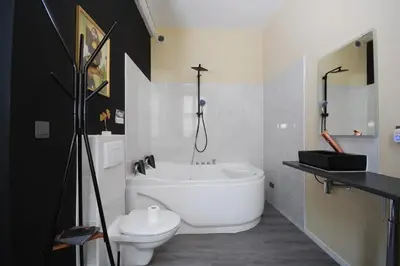 a bathroom with a white tub and a toilet at Baignoire Cosy Centre Narbonne in Narbonne