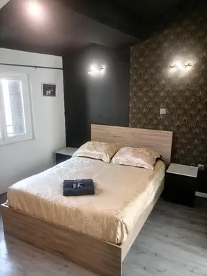 a bedroom with a large bed with a suitcase on it at Studio Baignoire centre ville in Narbonne
