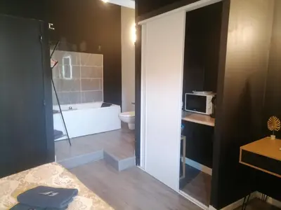 a bathroom with a tub and a toilet and a microwave at Studio Baignoire centre ville in Narbonne