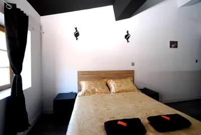 a bedroom with a bed with two pillows on it at Charmant Studio Baignoire in Narbonne
