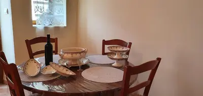 a dining room table with a bottle of wine and a wine glass at La maison de mon enfance ! Au cœur du Minervois ! in Félines-Minervois