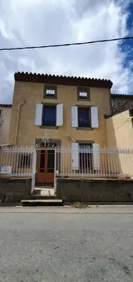 a house with a white fence in front of it at La maison de mon enfance ! Au cœur du Minervois ! in Félines-Minervois