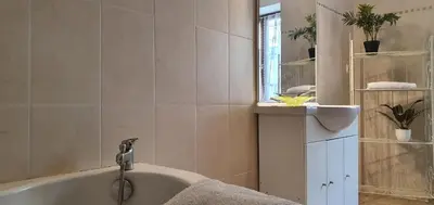 a bathroom with a bath tub with a sink and a mirror at La maison de mon enfance ! Au cœur du Minervois ! in Félines-Minervois