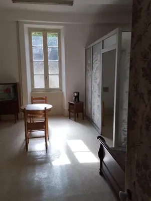 a room with a table and a bed and a window at Maison Alba La Source in Mazamet