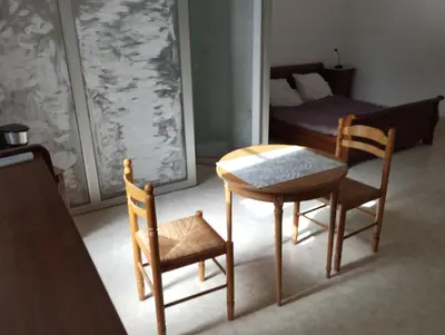 a room with a table and two chairs and a bed at Maison Alba La Source in Mazamet