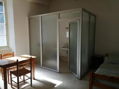 a room with a glass door with a table and a sink at Maison Alba La Source in Mazamet