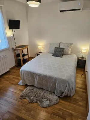 a bedroom with a bed with a gray comforter and two lamps at Chambre d'hôte Lempautoise in Lempaut