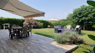 a patio with a table and chairs under an umbrella at Chambre d'hôte Lempautoise in Lempaut