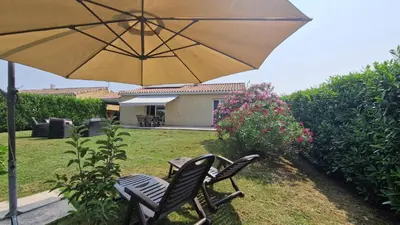 two chairs and a table with an umbrella at Chambre d'hôte Lempautoise in Lempaut