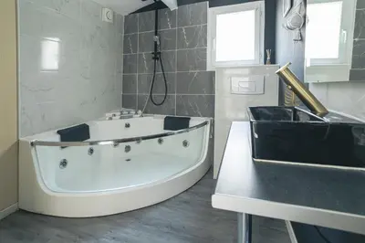 a bathroom with a white tub and a sink at Jacuzzi Terrasse Centre Narbonne in Narbonne