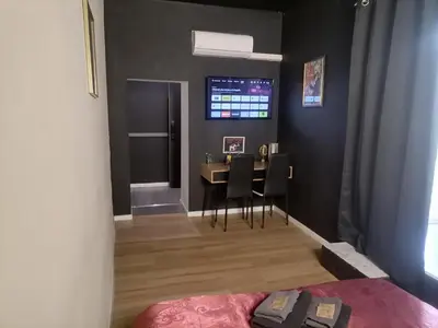 a bedroom with a table and chairs in a room at Jacuzzi Terrasse Centre Narbonne in Narbonne