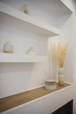 a white shelf with a vase on a mantle at Magnifique appartement plein centre, calme, Netflix in Mirepoix