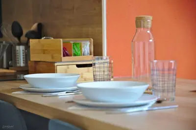a table with two bowls and a bottle of water at T2 chaleureux au centre de castelnaudary in Castelnaudary