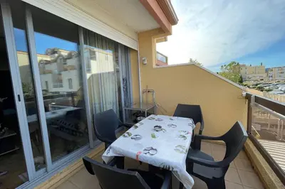 a balcony with a table and chairs on a balcony at Appartement terrasse sur le port, piscine, tennis in Gruissan