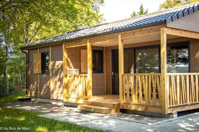 a wooden cabin with a porch and a deck at Au bois de Mars in Les Martys