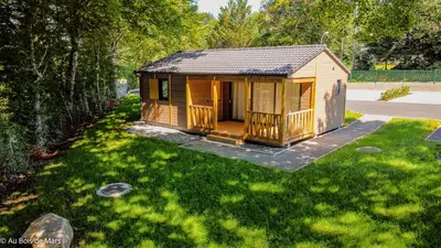 a small cabin in a yard with green grass at Au bois de Mars in Les Martys