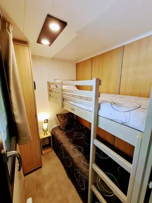 a small room with two bunk beds and a couch at Au bois de Mars in Les Martys
