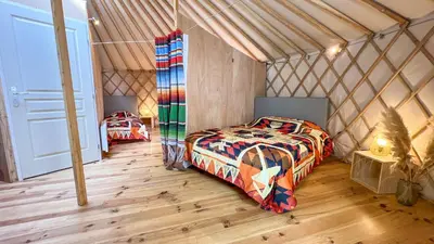 a bedroom with a bed in a yurt at Au bois de Mars in Les Martys