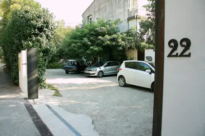two cars parked in a parking lot next to a building at Appartement Aloa in Carcassonne