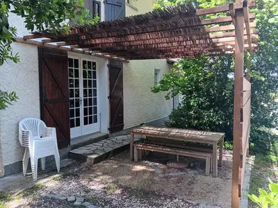 a picnic table and a bench in front of a house at El terret in Sigean